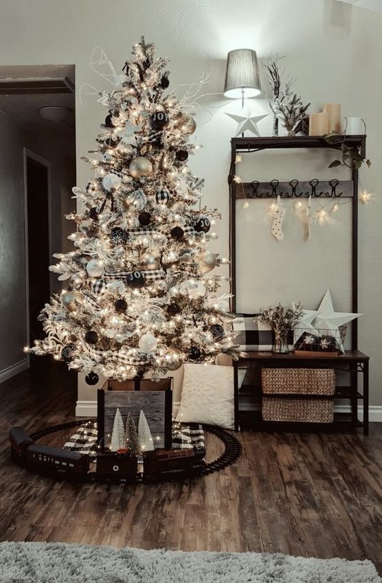 a farmhouse flocked Christmas tree with buffalo check ornaments and garlands, black and white ornaments and lights is a chic idea