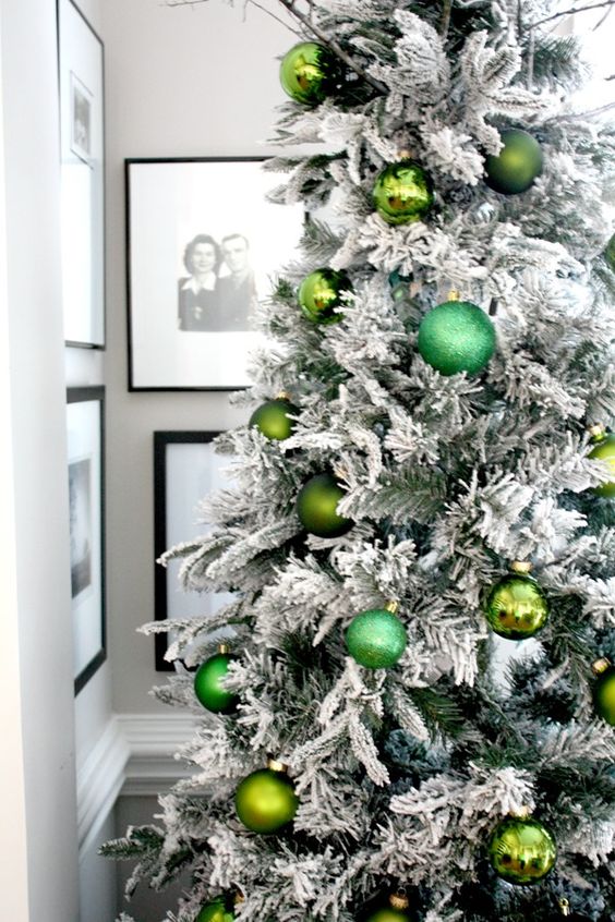 a flocked Christmas tree decorated with green ornaments of various shades looks glam, chic and bold and feels pretty natural at the same time