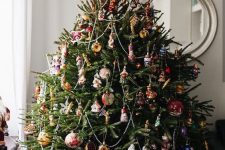 a lovely Christmas tree decorated with beaded garlands, colorful vintage ornaments and a red star tree topper