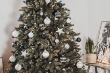 a lovely Christmas tree decorated with white pompoms, lights and a selection of gorgeous black and white ornaments and stars