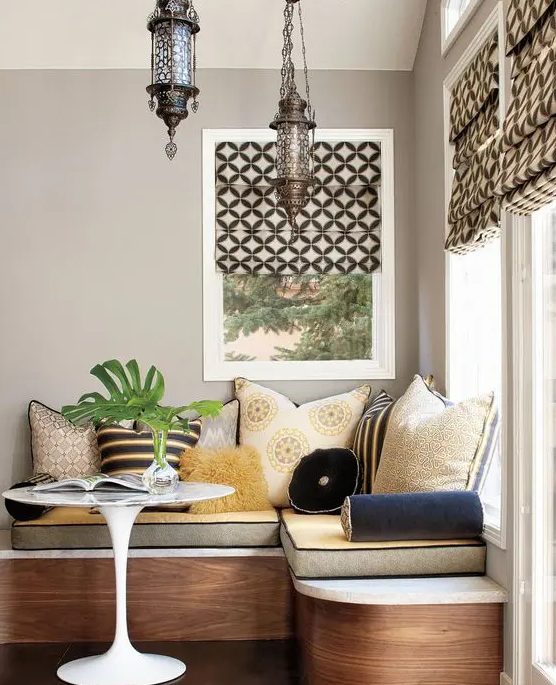 a luxurious banquette seating with lots of cushions and pillows plus storage inside plus beautiful Moroccan pendant lamps