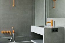 a minimalist bathroom fully made of concrete, with a floating vanity and a bathtub, a large mirror and orange fixtures is wow