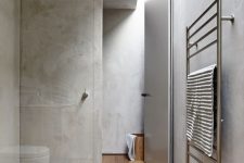 a minimalist bathroom with concrete walls and a hardwood floor for more warmth, a skylight for natural light