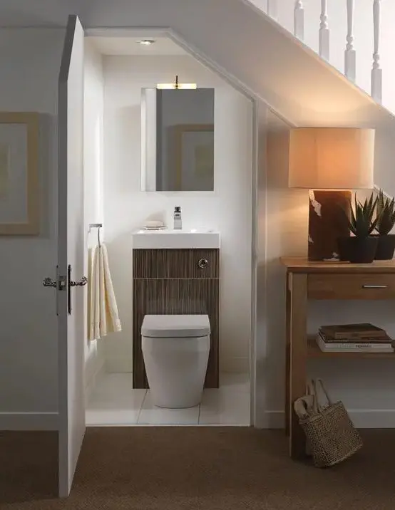 a minimalist powder room with a mirror and a sink plus toilet combo   you won't need more