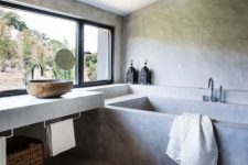 a modern ethnic bathroom with concrete walls and a floor, a bathtub and a floating vanity, a basket for storage and a sink