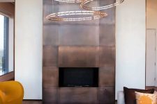 a modern fireplace clad with a darkened copper surround looks really wow and impressive and makes a bold statement