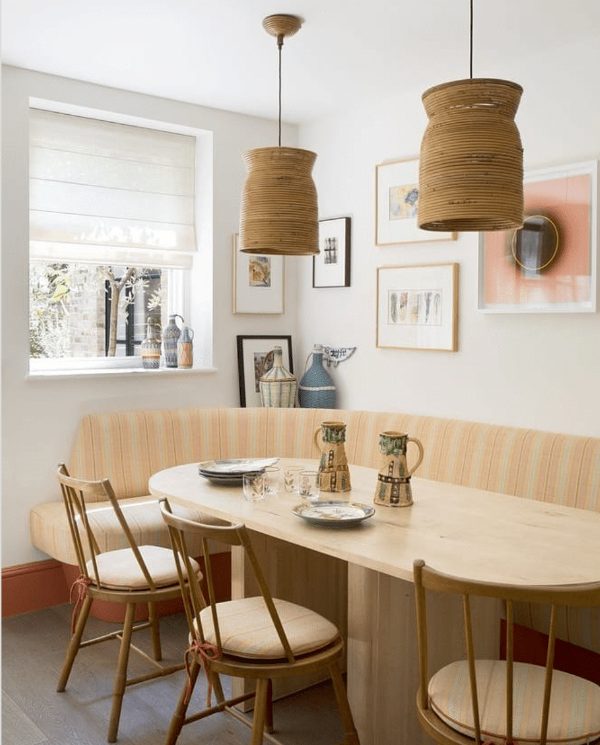 a modern rustic dining area with a printed cozy curved banquette seating, round chairs, cool bamboo pendant lamps