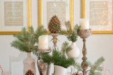 a natural Christmas tablescape with vintage jugs and candleholders, pinecones and evergreens is very cozy