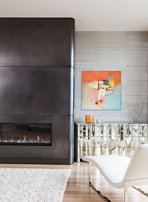 a neutral space done with a pretty white leather lounger, a catchy mirrored credenza and a black metal sheet fireplace that contrasts it a lot