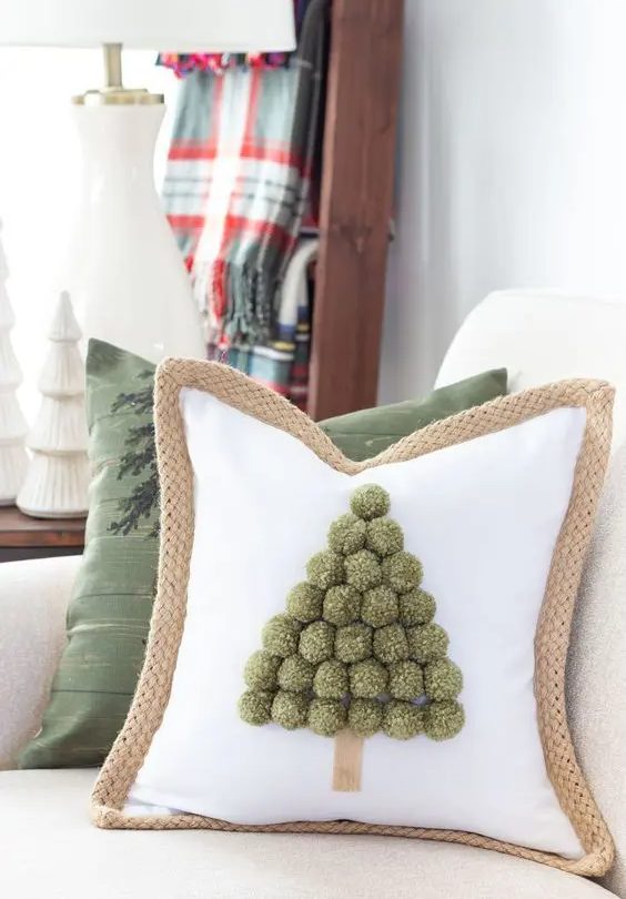 a pillow with a Christmas tree composed of green pompoms is a lovely idea for a holiday space