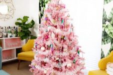 a pink Christmas tree with colorful ornaments and lights, with gold touches looks pretty and very chic