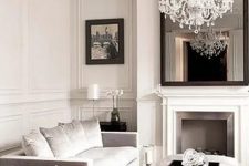 a refined and glam Parisian-style living room done in neutrals, with dark touches for a bit of drama and with gorgeous ornated crown molding and a ceiling medallion