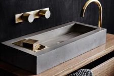 a refined minimalist concrete sink paired with gold fixtures is a gorgeous idea for a contemporary bathroom