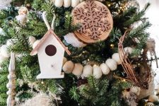 a rustic woodland Christmas tree with ornaments, pinecones, wooden beads, tree slice snowflake ornaments and other stuff