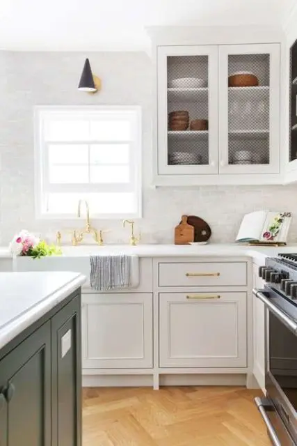 a serene neutral kitchen with sgaker style cabinets, crown molding that connects the upper cabinetry with the ceiling and gold touches for a more glam feel