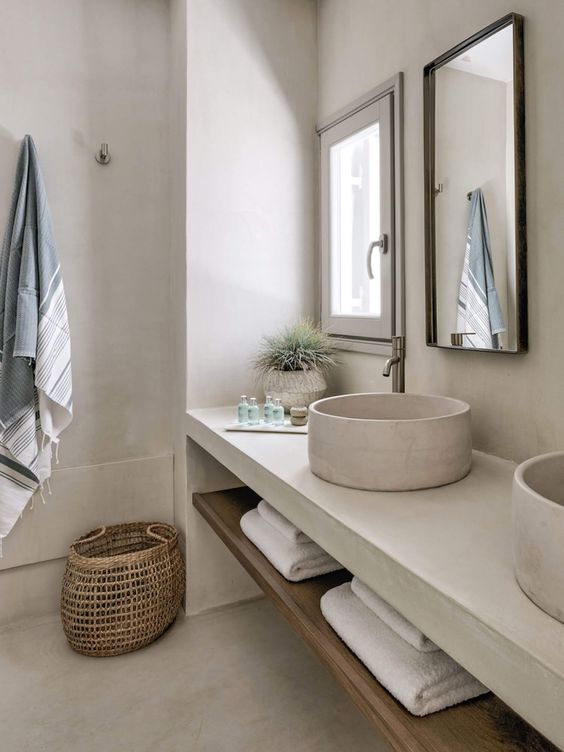 a serene white concrete bathroom with all things concrete around, a built in vanity, a concrete countertop and a round sink