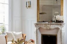a sophisticated Parisian living room with ornated crown molding, with a refined fireplace and a gorgeous mirror ina gilded frame, with neutral furniture
