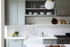 a sophisticated dove grey kitchen with shaker cabinets, open shelves, a white tile backsplash and white quartz countertops