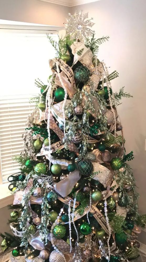 a super shiny and glam Christmas tree decorated with white and green ornaments of various shades, ribbons, lights, twigs and beads
