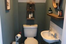 a teal powder room with white appliances, an open shelf, a mirror hanging, some decor and a radiator