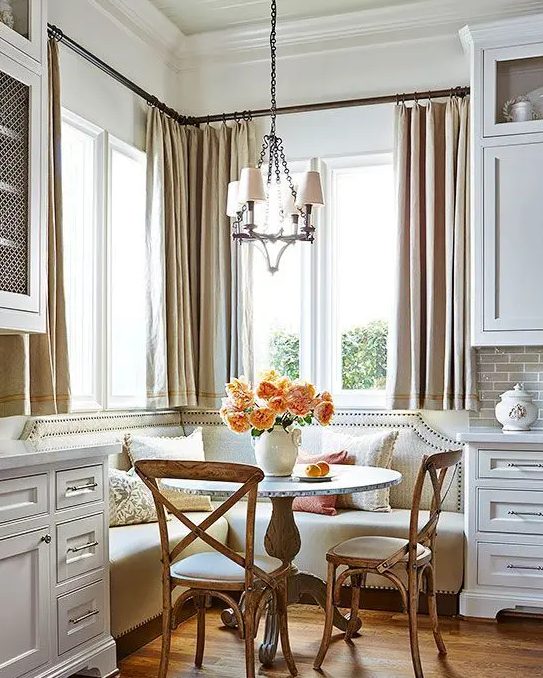 a traditional and refined space with a vintage feel and a corner banquette seating with a nail trim