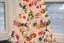a white Christmas tree with colorful vintage ornaments and lights is a fun and cool idea to go for