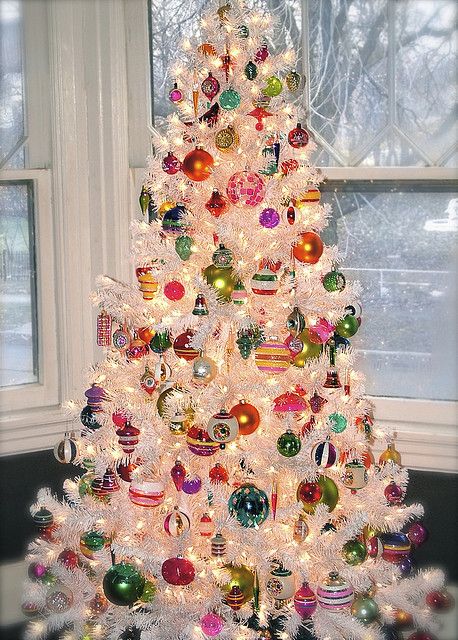 a white Christmas tree with colorful vintage ornaments and lights is a fun and cool idea to go for