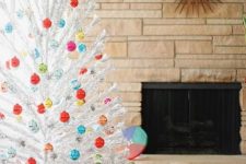 a white Christmas tree with lots of colorful Christmas ornaments looks pretty, chic and vintage