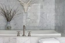 a white marble bathroom done with tiles – an amazing idea to use if you aren’t ready to splurge on real marble
