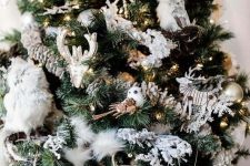 a winter woodland Christmas tree with pinecones, owls, wooden snowflakes, deer heads, lights and faux fur is amazing