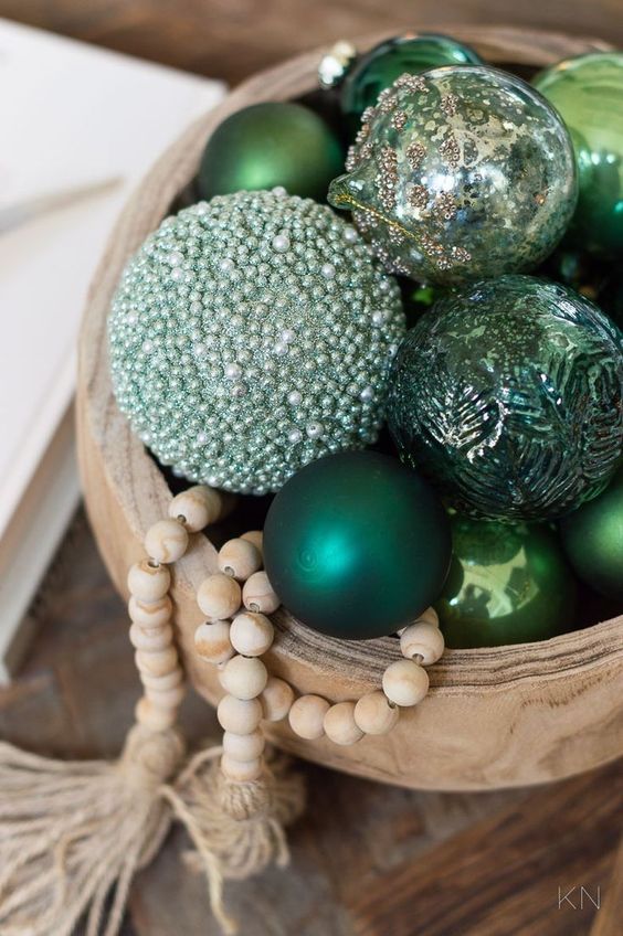 a wooden bowl with green and embellished ornaments, wooden beads is a cool Christmas decor idea