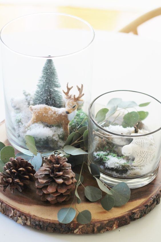 a woodland Christmas centerpiece of a tree slice, pinecones, evergreens, faux trees, a deer and some moss