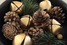 an elegant woodland Christmas decoration of a bowl with pinecones and evergreens is a cool centerpiece idea