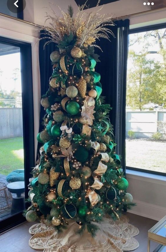 an emerald Christmas tree with gold and green ribbons, branches and leaves plus lights is amazing