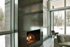an ultra-modern fireplace clad with dark metal sheets looks very eye-catching and even show-stopping