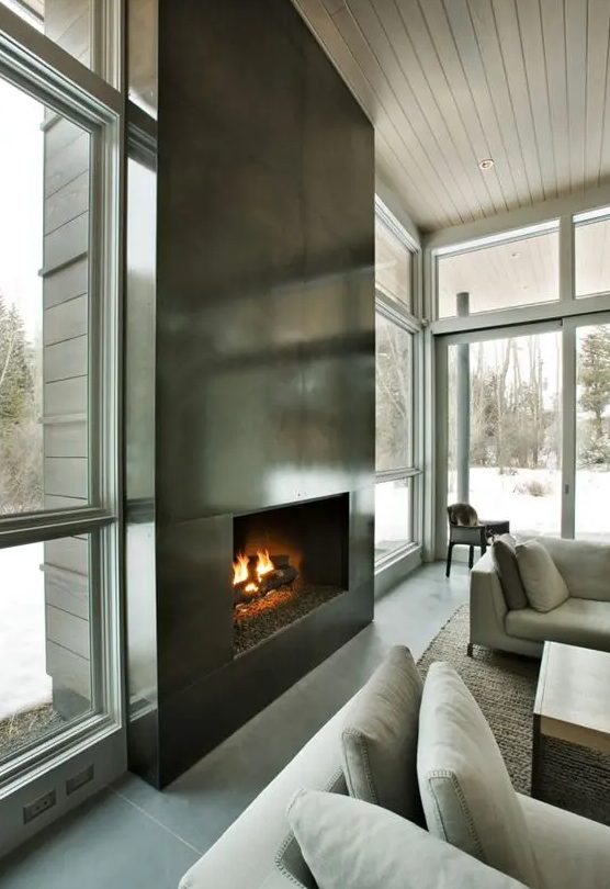 an ultra modern fireplace clad with dark metal sheets looks very eye catching and even show stopping