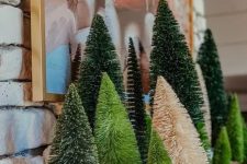 cool woodland Christmas mantel decor with various bottle brush trees in green and neutrals is easy and cool