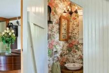 floral wallpaper is a trend for bathroom decor, and here it’s rocked right with a vintage bowl sink and wooden furniture
