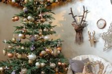 lovely woodland glam Christmas decor with a tree with gold, brown and pearly ornaments, deer heads, ornaent garlands and vine trees