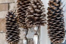 stylish and simple woodland Christmas decor with large pinecones on elegant candleholders is amazing