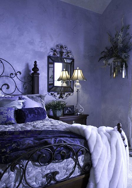 a very peri bedroom with limewashed walls, a black forged bed, a black nightstand with drawers and a refined lamp