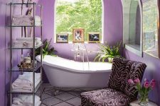 09 a very peri bathroom with an arched ceiling, a refined vintage bathtub, a zebra print chair and a glass shelf