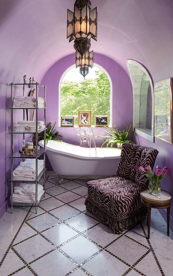 a very peri bathroom with an arched ceiling, a refined vintage bathtub, a zebra print chair and a glass shelf