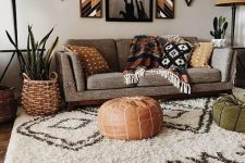 10 a bold African-inspired interior with a grey sofa and earthy pillows and blankets, poufs, tan floor lamps and potted plants