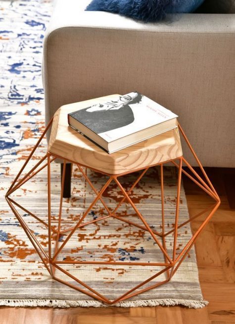 a side table with a hexagon tabletop and a geometric copper base is a bold and catchy piece to spruce up your room