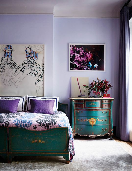 a vintage very peri bedroom with vintage teal furniture, some art and purple and pink textiles