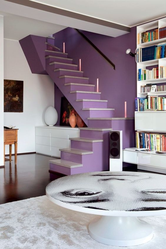a contemporary space with a very peri staircase for an accent and neon lights, a bold photo coffee table and a bookcase