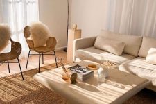 21 a warm neutral living room with a creamy sofa, woven chairs, a jute rug, a white stone table and an airy floor lamp