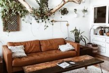 23 a brown leather sofa and a reclaimed wood coffee table give enough texture to the room, and greenery refreshes it a lot