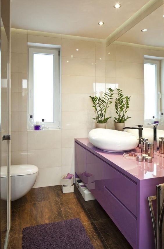 a neutral bathroom with glossy neutral tiles, a very peri floating vanity, white appliances and built in lights